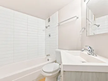 Bathroom with tub and vanity at Julian Square Apartments